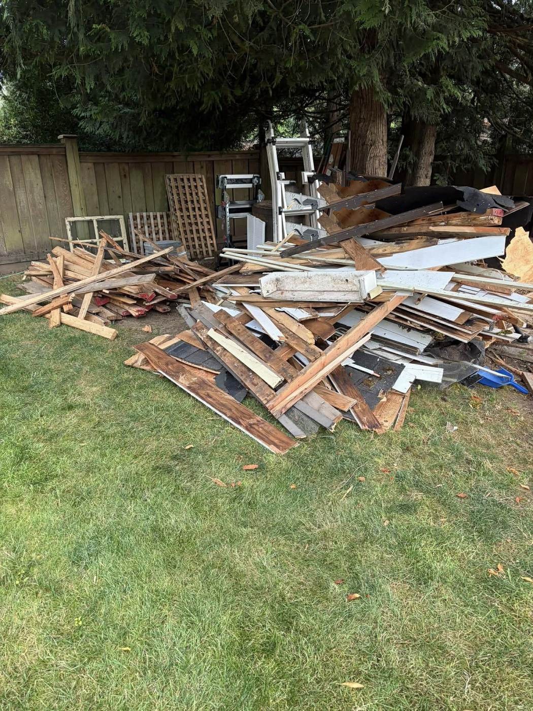 Yard piled with lumber and building debris cleared during a property clear-out